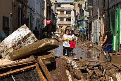 Residents remove destroyed furniture from their houses in Sant Llorenc.