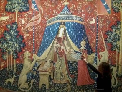 Una dona davant del tapís principal de la Dama de l'unicorn, al Museu de Cluny, a París.