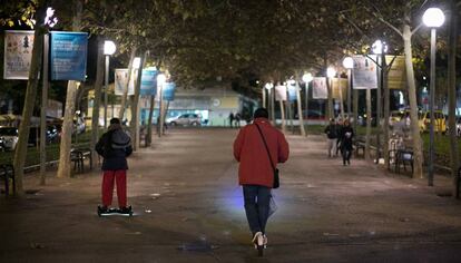 Una persona circula con un patinete eléctrico por el centro de la Rambla del Carme.