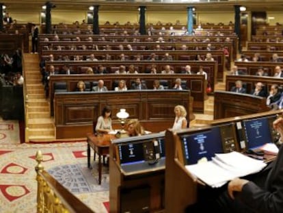 Rajoy (derecha) sigue una intervenci&oacute;n de Zapatero en el Congreso.