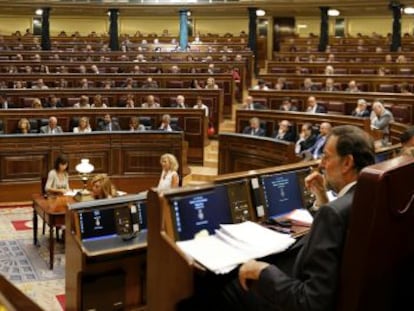 Rajoy (derecha) sigue una intervenci&oacute;n de Zapatero en el Congreso.