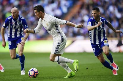 Ronaldo corre con la pelota ante los jugadores del Alavés, Edgar Méndez (d) y Gaizka Toquero.