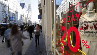 Varias personas caminan por la Gran V&iacute;a de Madrid en la jornada del &quot;Black Friday&quot;, el d&iacute;a m&aacute;s importante de rebajas y una costumbre de consumo que se ha popularizado por todo el mundo.