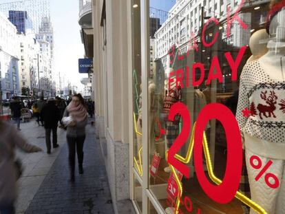 Varias personas caminan por la Gran V&iacute;a de Madrid en la jornada del &quot;Black Friday&quot;, el d&iacute;a m&aacute;s importante de rebajas y una costumbre de consumo que se ha popularizado por todo el mundo.