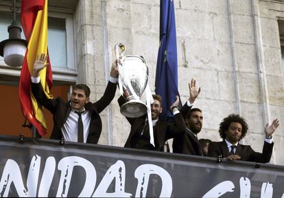 Iker Casillas, Sergio Ramos, &Aacute;lvaro Arbeloa  y el brasile&ntilde;o Marcelo Vieira, saludan a los aficionados desde el balc&oacute;n la sede de la Comunidad de Madrid con la copa de la Liga de Campeones.