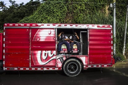 Un camión de la empresa Coca-Cola está siendo custodiado por dos guardias de seguridad privada. Esta es la forma más común de garantizar que los productos lleguen a su destino sin ser asaltados.