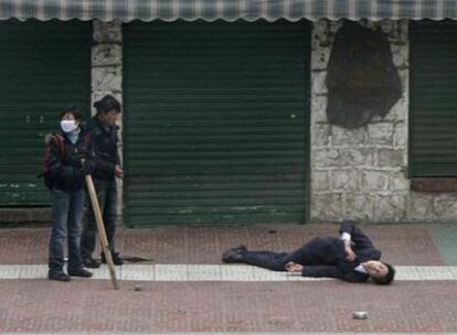 Un tibetano yace herido en la calle tras los enfrentamientos con la policía china en el centro de Lhasa, ayer.