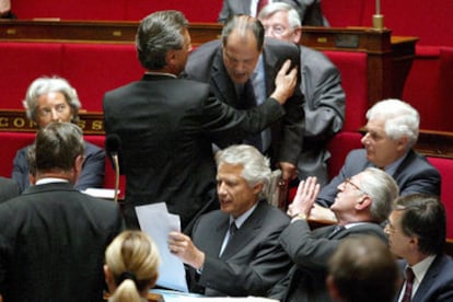 Villepin recoge sus papeles mientras es increpado por el diputado socialista Jean-Cristophe Cambaledis, ayer en la Asamblea Nacional.