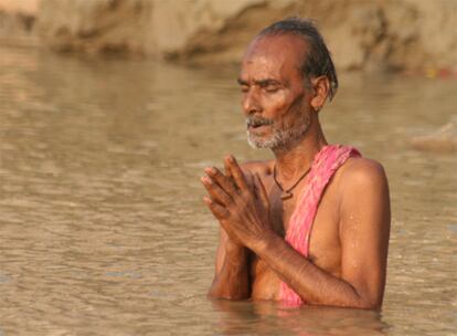 Un hombre rezando en el río Ganges, Benarés