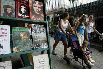 Tres mujeres pasean por las calles del centro de La Habana ante una librería.