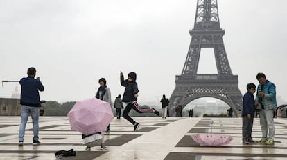 Turistas pasean y hacen fotografías en París.