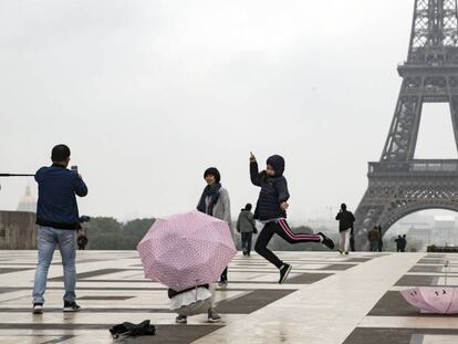 Turistas pasean y hacen fotograf&iacute;as en Par&iacute;s.