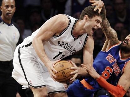 Brook L&oacute;pez, con el bal&oacute;n, pugna con Tyson Chandler.