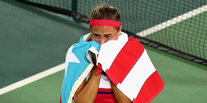 Mónica Puig festeja con la bandera de Puerto Rico.