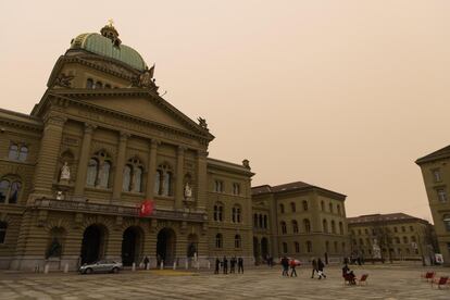 El palacio Federal suizo, en Berna, rodeado por polvo del Sáhara que colorea el cielo con un tono anaranjado.