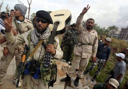 Rebeldes libios hacen el signo de la victoria durante los &uacute;ltimos combates en Sirte (Libia).
