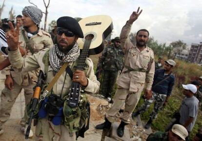 Rebeldes libios hacen el signo de la victoria durante los &uacute;ltimos combates en Sirte (Libia).