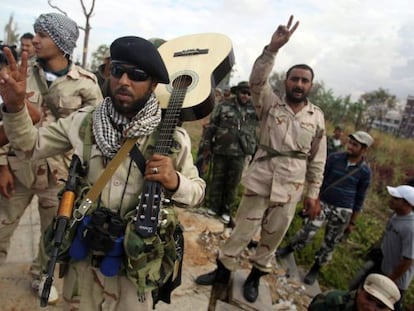 Rebeldes libios hacen el signo de la victoria durante los &uacute;ltimos combates en Sirte (Libia).