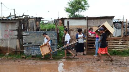 Moradores carregam móveis de área em São Mateus, na zona leste. Polícia diz que ocupantes tentaram resistir à retirada lançando pedras em agentes.