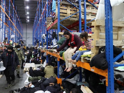 Cientos de refugiados, el jueves en un centro logístico bielorruso cerca de Polonia.