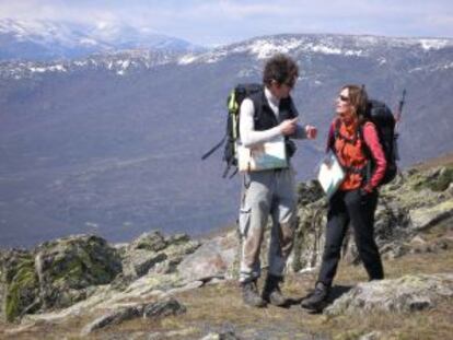Dos excursionistas, con el Pico del Lobo, en la sierra de Ayll&oacute;n,  al fondo.  