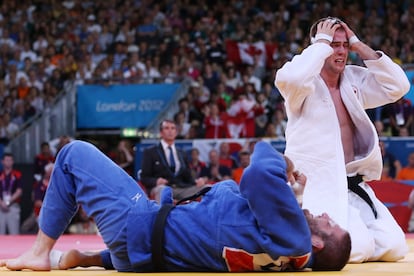 El canadiense Antoine Valois-Fortier se llevaba las manos a la cabeza al borde del llanto al ser consciente de que había ganado el bronce en judo. En el suelo, Travis Stevens asume su derrota con expresión trágica.