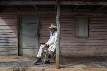 Manuel Ojeda, anciano de 77 años, fuma un cigarrillo en la puerta de su casa, en la aldea de Chafarinas (Artemisa). La población cubana atraviesa por un marcado proceso de envejecimiento. En las zonas rurales es común que muchos campesinos continúen trabajando en el campo tras su jubilación oficial. Después de trabajar como güajiro para el Estado durante décadas, Manuel trabajó varios años en una granja de iniciativa privada. Tan solo hace dos que dejó de acudir al campo.