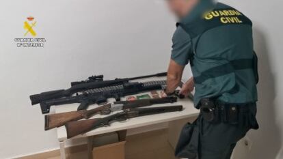 Un agente de la Guardia Civil revisa las armas intervenidas a los arrestados por venta de drogas a pequeña escala en Ondara (Alicante).