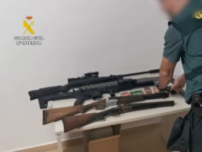 Un agente de la Guardia Civil revisa las armas intervenidas a los arrestados por venta de drogas a pequeña escala en Ondara (Alicante).