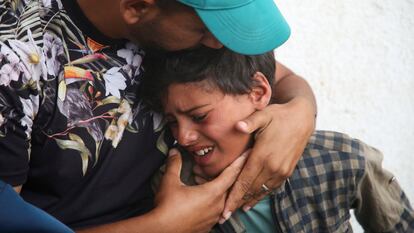 Un niño es consolado mientras llora cerca de los cuerpos de palestinos muertos en ataques israelíes en Rafah, al sur de la Franja de Gaza, el 27 de abril de 2024.