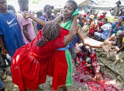 Ritual con sacrificios. El matarife degüella a la vaca y un chorro de sangre salpica al grupo mientras la santera es abrazada por otra mujer.