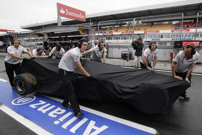 Los mecánicos de McLaren trasladan el monoplaza accidentado de Hamilton.