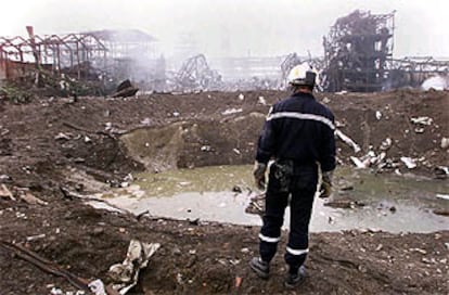 Un bombero se asoma al cráter de 50 metros que se abrió en el punto de la primera explosión en la química AZF de Toulouse.