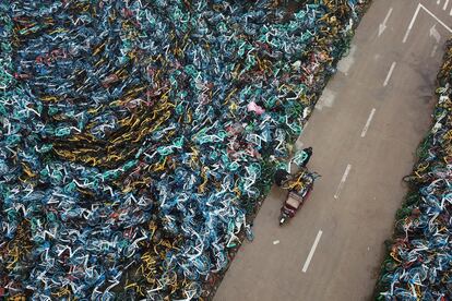 Oficiales de gestión urbana transportan una bicicleta del servicio municipal en Hefei, provincia de Anhui (China), el 3 de diciembre de 2018.