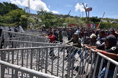 Hombres armados con palos intentan quitar la barricada que colocó la policía, este 10 de julio.