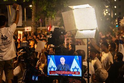 La televisión israelí retransmite una rueda de prensa de Netanyahu durante una manifestación de los familiares de los rehenes en Gaza, el 18 de noviembre de 2023, en Tel Aviv.