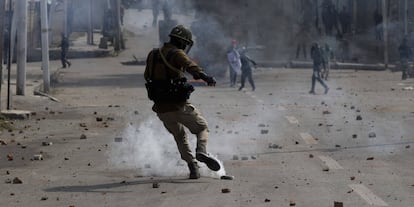 Un policía indio patea un proyectil de gas lacrimógeno lanzado por manifestantes, en Srinagar (India).