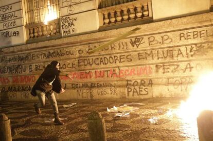 Los encapuchados, que se integraron como miembros de un grupo conocido como "black blocs", que defiende el uso de la violencia en las protestas, quebraron ventanales de algunas agencias bancarias e intentaron invadir la sede de la Cámara municipal en Río de Janeiro (Brasil), 7 de octubre de 2013.