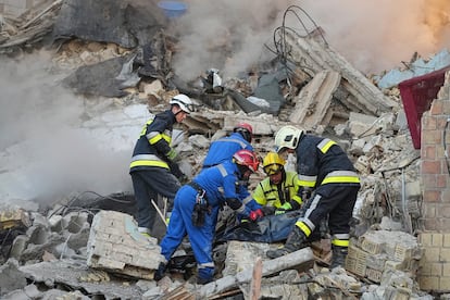 Bomberos recuperan el cuerpo de una víctima de un edificio dañado por un ataque ruso en la capital de Ucrania.