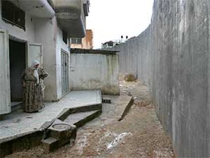 Una mujer palestina observa desde la puerta de su casa el muro construido por Israel.