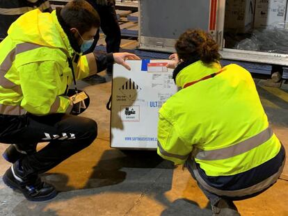 Dos trabajadores comprueban una caja con vacunas en el aeropuerto de Vitoria, en una imagen facilitada por la Delegación del Gobierno del País Vasco.