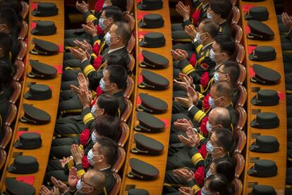 Militares, con mascarilla, aplauden durante la ceremonia de imposición de medallas a decenas de trabajadores sanitarios involucrados en la lucha contra la covid. El acto tuvo lugar en un abarrotado Gran Palacio del Pueblo, en Pekín (China), sede de las reuniones anuales del Parlamento chino o de las recepciones a dignatarios extranjeros.