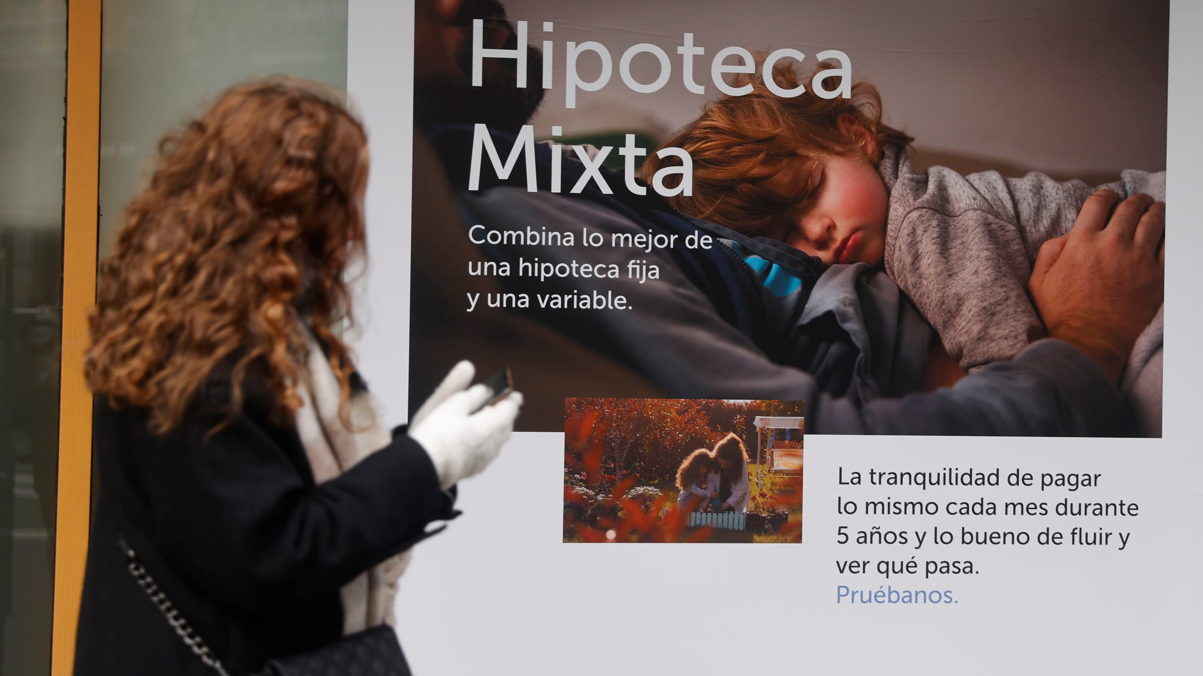 Una joven pasa por delante de un anuncio de hipotecas en Bilbao, en una imagen de archivo.