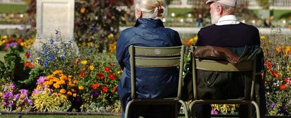 Dos personas mayores sentados en un parque de París.