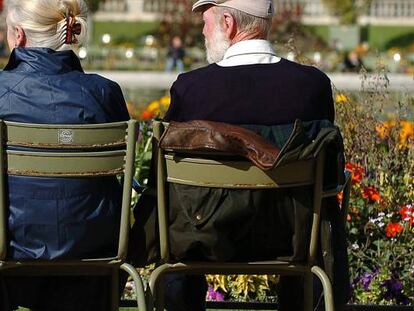 Dos personas mayores sentados en un parque de París.