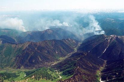 Vista aérea de las áreas montañosas de Siberia devoradas por un inmenso incendio forestal y del humo generado por el fuego.