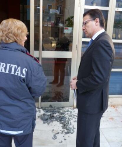 El secretario general del PP valenciano, Serafín Castellano, junto a una vigilante ante la sede del partido.