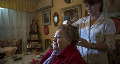 La cuidadora Ana Mar&iacute;a L&oacute;pez atiende a Antonia Carrasco en su casa de Ja&eacute;n.