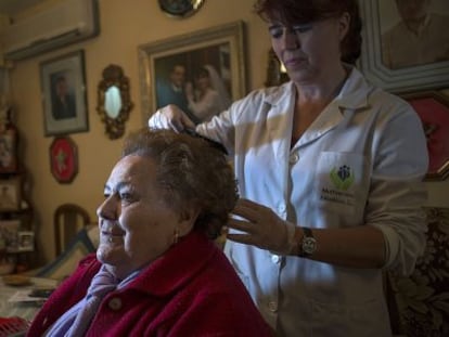 La cuidadora Ana Mar&iacute;a L&oacute;pez atiende a Antonia Carrasco en su casa de Ja&eacute;n.