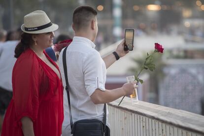 Dos turistas observan el operativo policial desde el paseo marítimo.